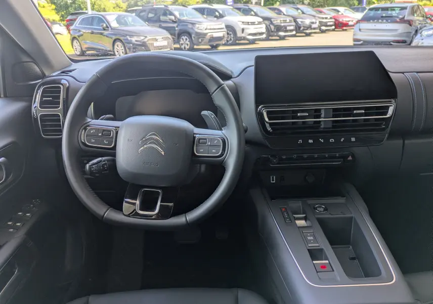 Vue intérieure centrée sur le volant et la console centrale du Citroën C5 Aircross noir Perla, avec écran tactile et commandes intégrées.
