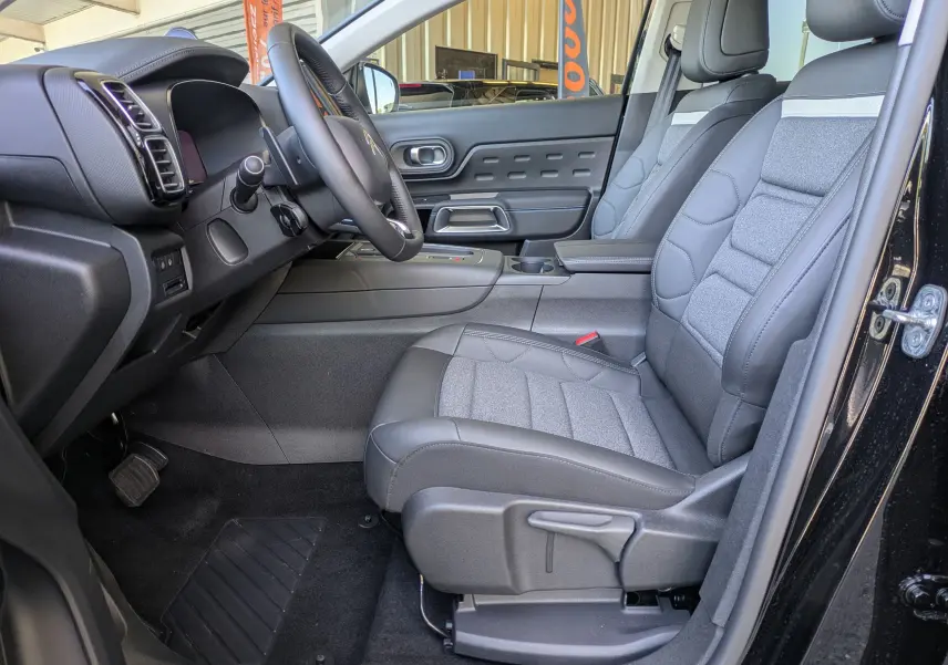 Vue intérieure côté conducteur du Citroën C5 Aircross noir Perla, avec sièges tissu/TEP gris et volant cuir croûte.