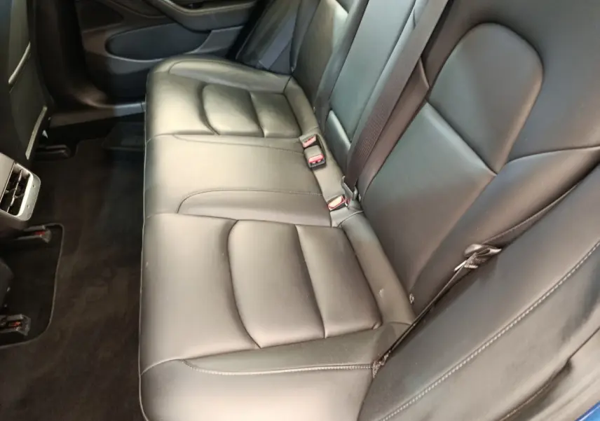 Vue intérieure côté droit sur la banquette arrière en cuir noir du Tesla Model 3 Long Range 2020, avec ceinture de sécurité visible.