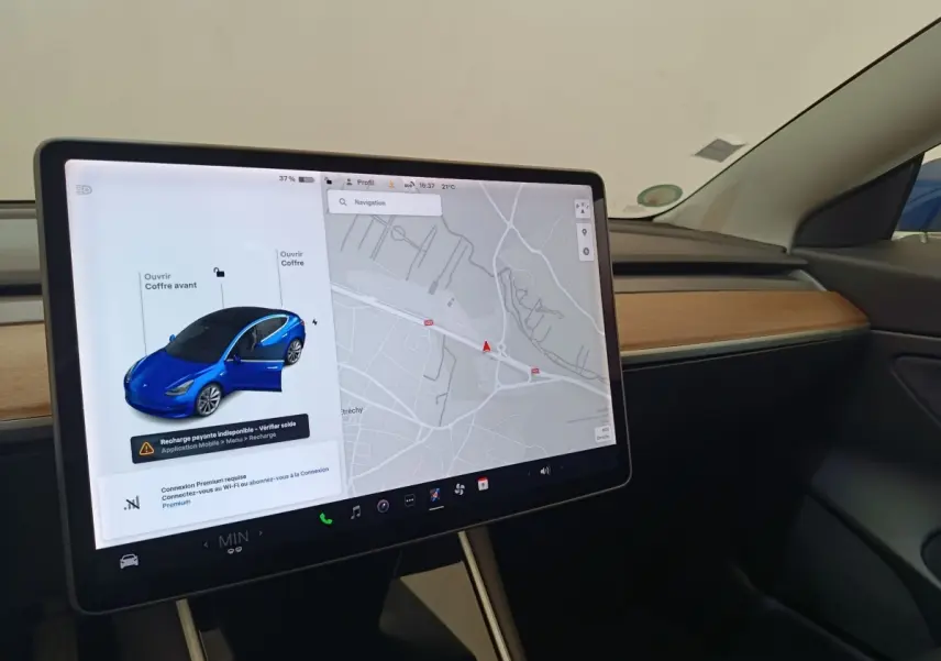 Écran tactile central affichant la navigation et une Tesla Model 3 bleue vue de 3/4 avant avec porte ouverte.