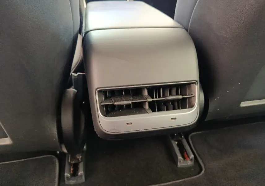 Gros plan sur la console centrale arrière noire avec bouches d’aération du Tesla Model 3 Long Range 2020.