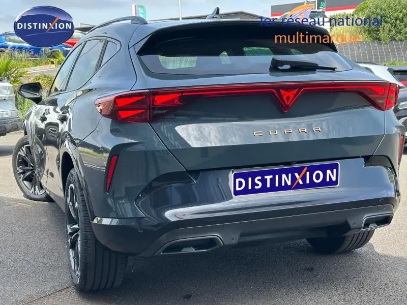 Vue 3/4 arrière d'un CUPRA Formentor bleu avec feux arrière LED et double sortie d'échappement.