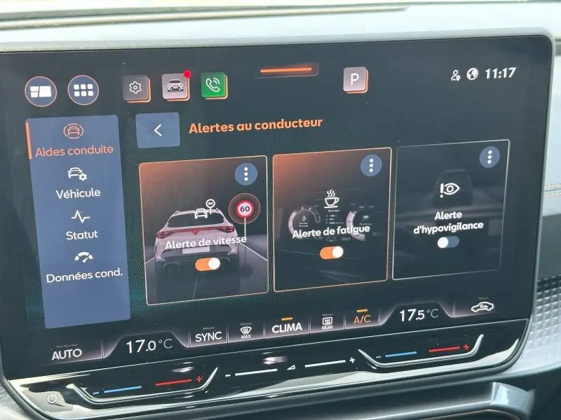 Écran tactile intérieur de la CUPRA Formentor bleu montrant les alertes au conducteur avec commandes climatisation en dessous.