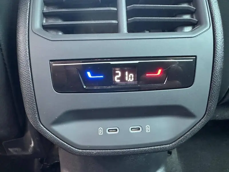 Gros plan sur la commande de climatisation arrière avec affichage digital à 21°C et ports USB du CUPRA Formentor bleu.