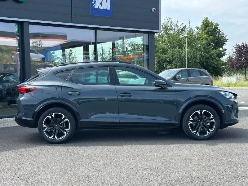 Vue latérale droite d'un CUPRA Formentor bleu foncé 2025 avec jantes alliage noires et détails sportifs marqués.