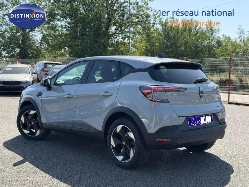 Renault Captur 1.8 E-Tech gris Rafale métallisé, vue 3/4 arrière droit avec jantes alu noires et vitres surteintées.
