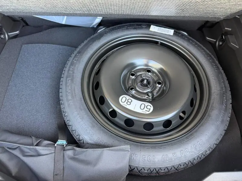 Vue rapprochée de la roue de secours noire dans le coffre du Renault Captur gris Rafale métallisé 2026.