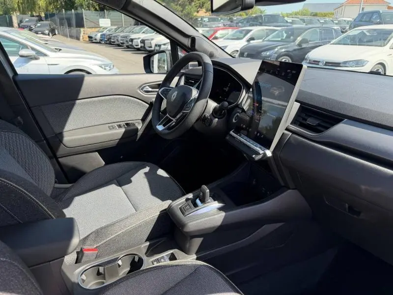 Vue intérieure côté conducteur du Renault Captur 2026 gris Rafale, avec écran tactile vertical et volant multifonction.