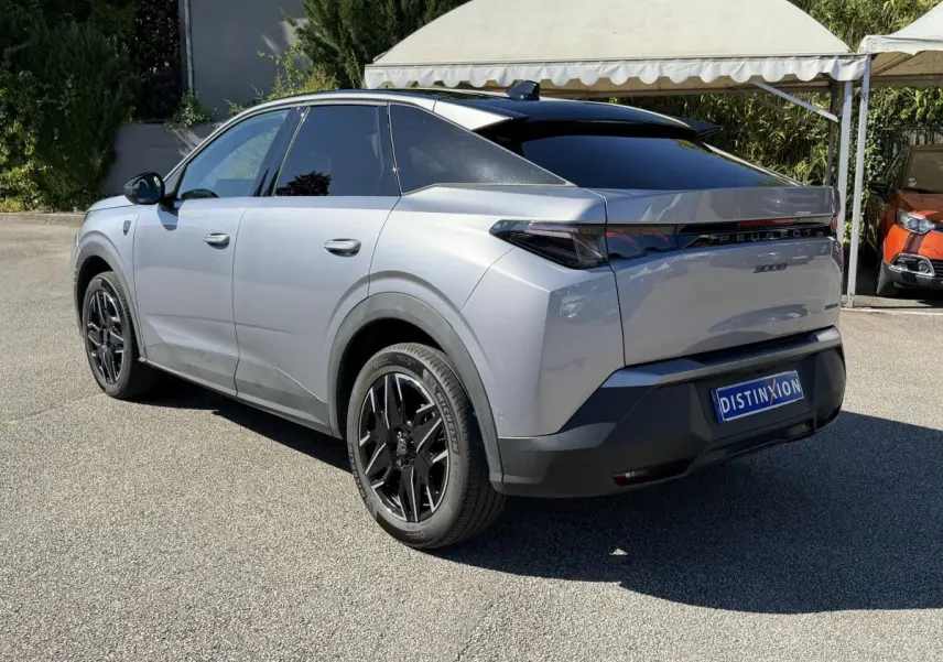 Peugeot 3008 gris clair vue 3/4 avant droit, avec calandre distinctive et jantes noires stylisées.