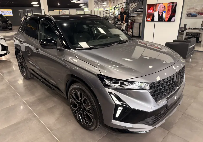 Renault Austral full hybrid gris schiste avec toit noir, vue 3/4 avant mettant en valeur ses optiques LED et jantes noires.