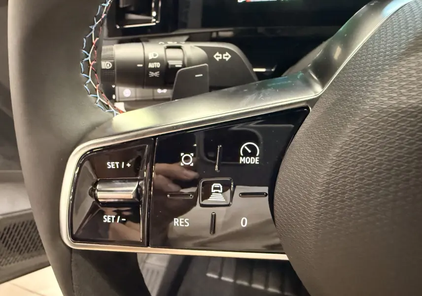 Gros plan sur les commandes au volant du Renault Austral 2026, finition Esprit Alpine avec surpiqûres tricolores.