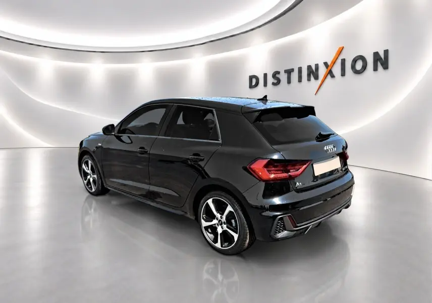 Audi A1 Sportback noir vue 3/4 arrière droit dans un showroom lumineux avec jantes alu distinctives.