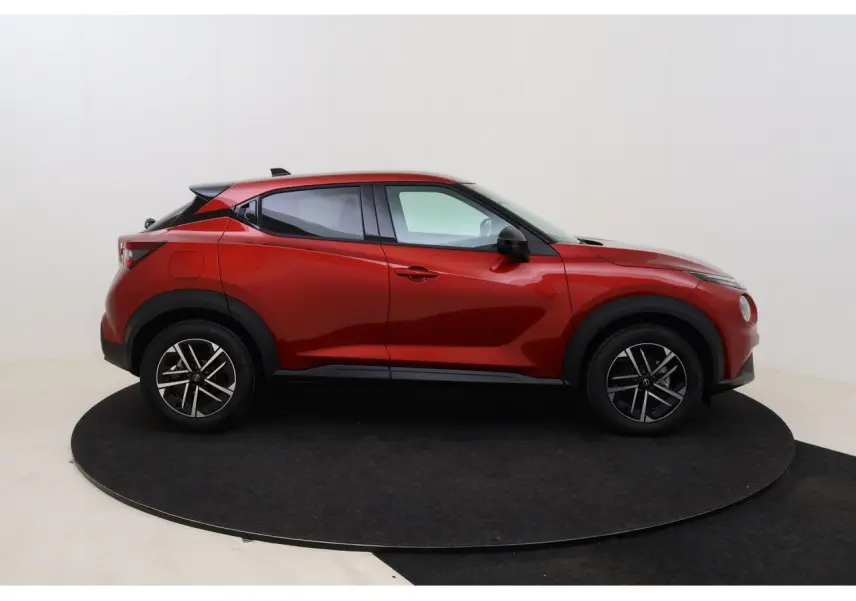 Profil latéral droit du Nissan Juke 2026 rouge Fuji Sunset avec jantes alliage 17 pouces et détails noirs contrastants.