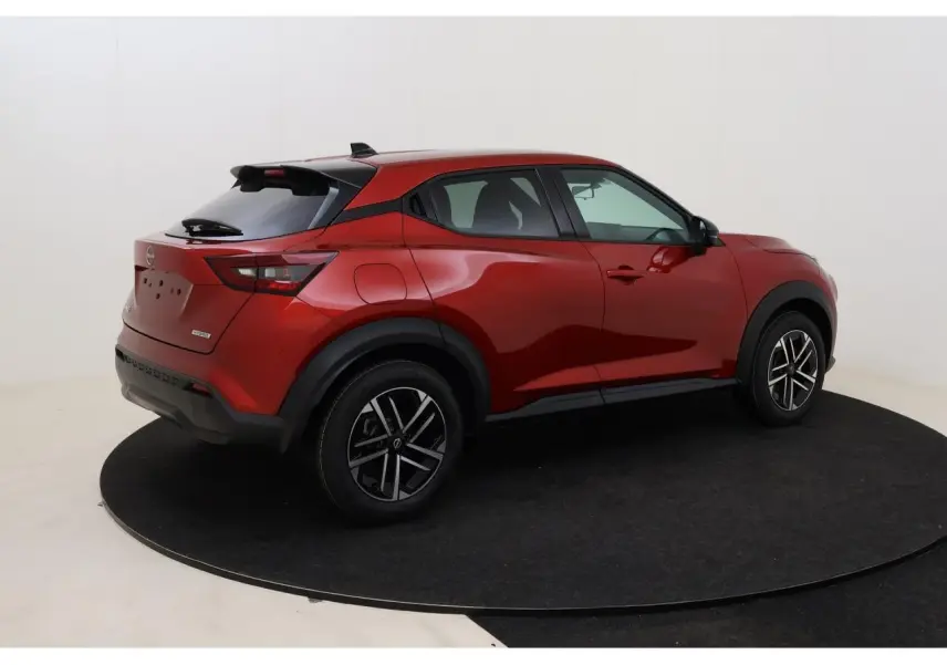 Nissan Juke rouge Fuji Sunset vu de trois quarts arrière droit, jantes alliage et toit noir contrasté.