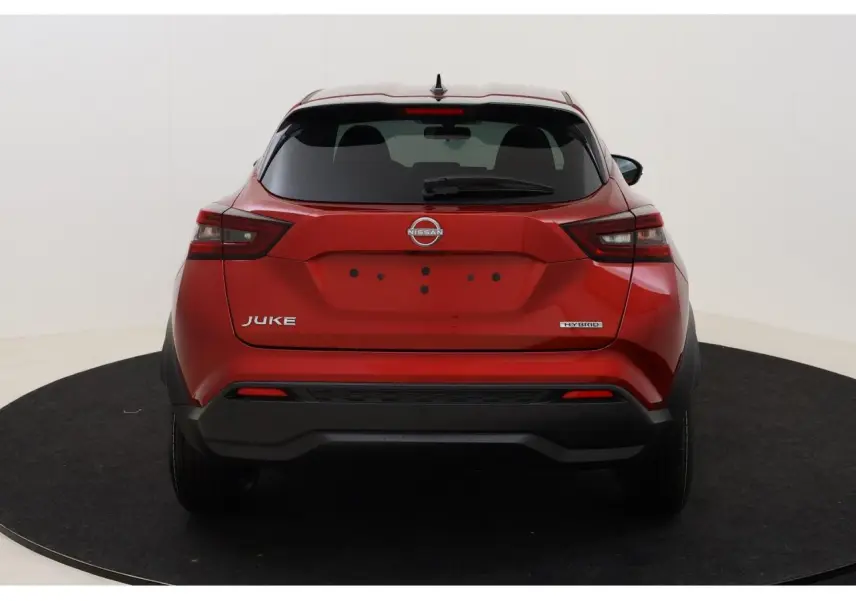Vue arrière d'un Nissan Juke rouge Fuji Sunset 2026 avec badge Hybrid et lunette arrière teintée.