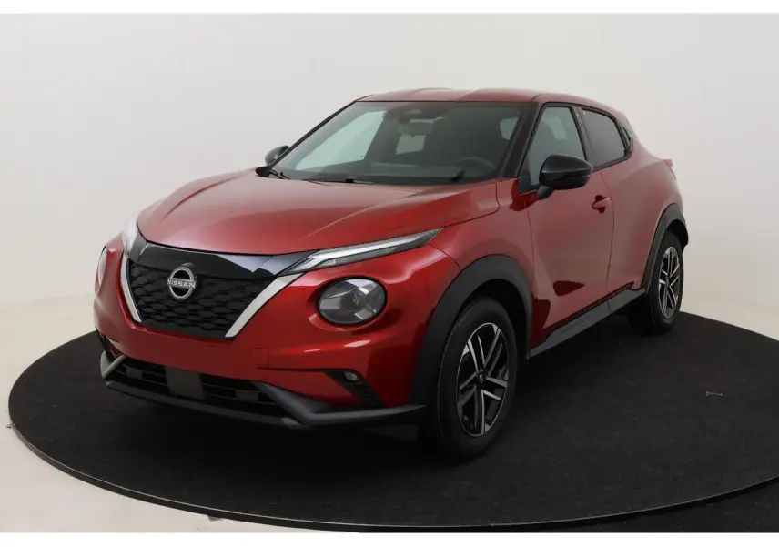 Nissan Juke 2026 rouge Fuji Sunset en 3/4 avant droit, avec calandre noire et jantes alliage 17 pouces.