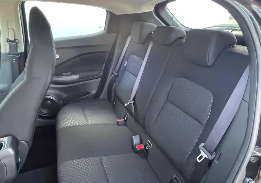 Vue intérieure côté droit montrant la banquette arrière noire et les appuis-tête du Nissan Juke II 2024 gris ceramic.