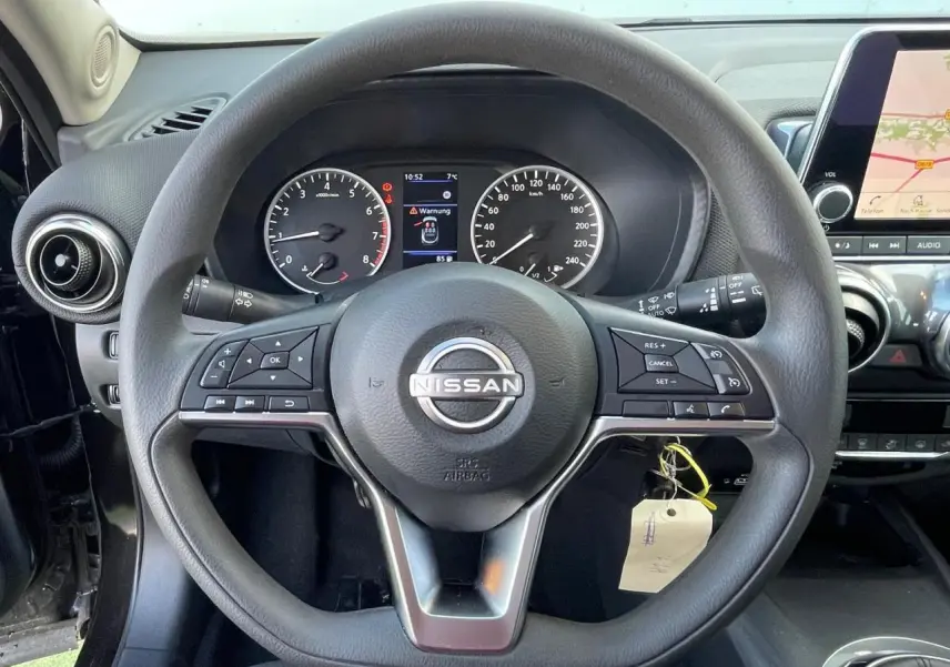 Vue rapprochée du volant noir de Nissan Juke 2024 avec tableau de bord digital et écran tactile de navigation.