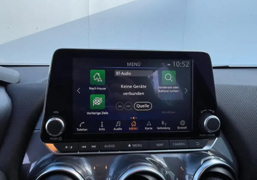 Écran tactile central du Nissan Juke II gris ceramic 2024 avec commandes audio et climatisation visibles