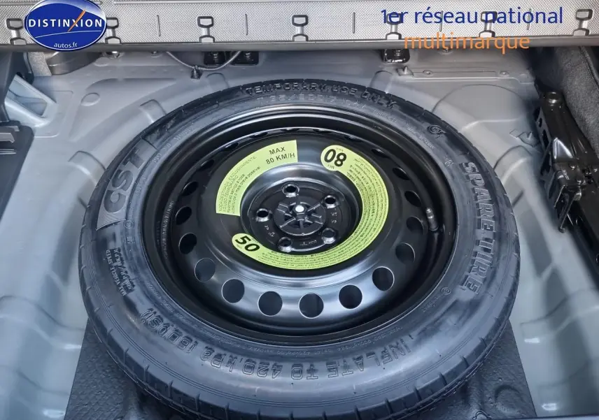 Roue de secours en gros plan dans le coffre d'un Hyundai Tucson blanc atlas 2025 hybride essence.