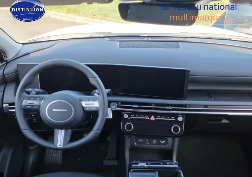 Vue intérieure du tableau de bord et volant cuir noir du Hyundai Tucson 2025 hybride essence, avec écran tactile panoramique.