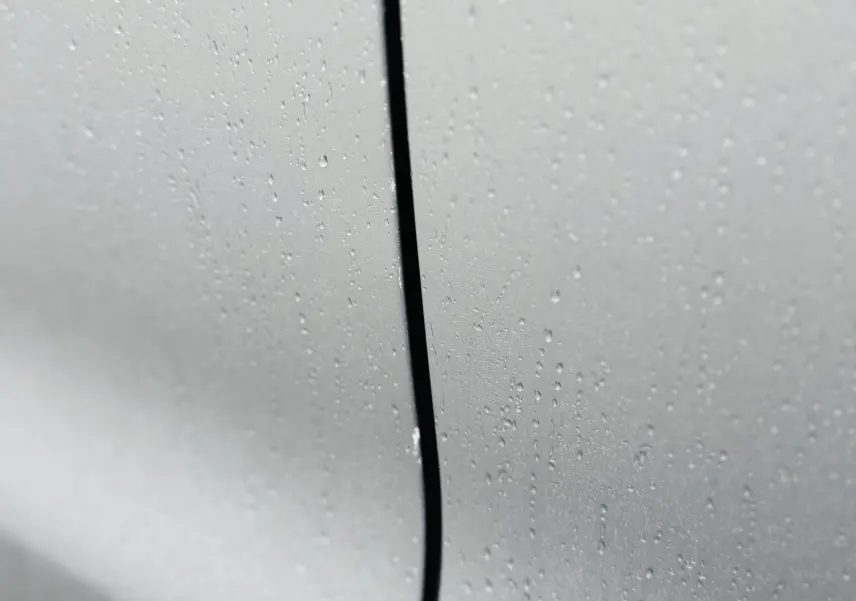 Gros plan sur la portière grise Artense d'une Citroën C3 Aircross 2020, avec gouttes de pluie visibles.