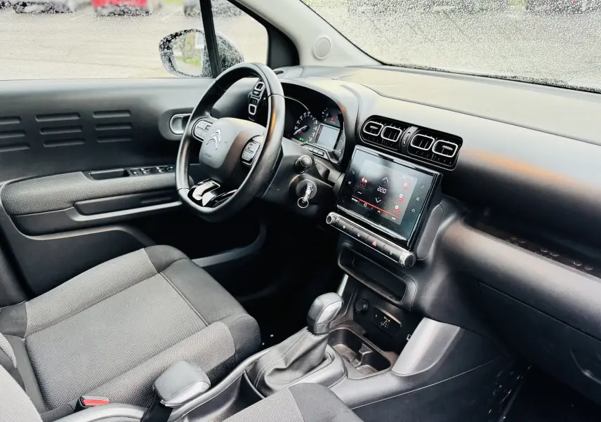Intérieur avant droit de la Citroën C3 Aircross gris avec tableau de bord moderne et écran tactile central.