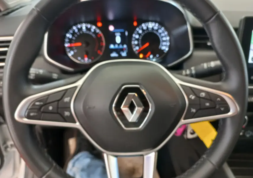 Vue rapprochée du volant cuir noir multifonctions de la Renault Clio Business blanche de 2021.