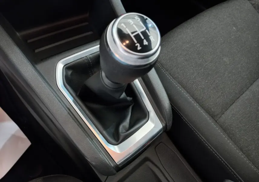 Gros plan sur le levier de vitesses manuel noir et argenté de la Renault Clio Business blanche, côté console centrale.