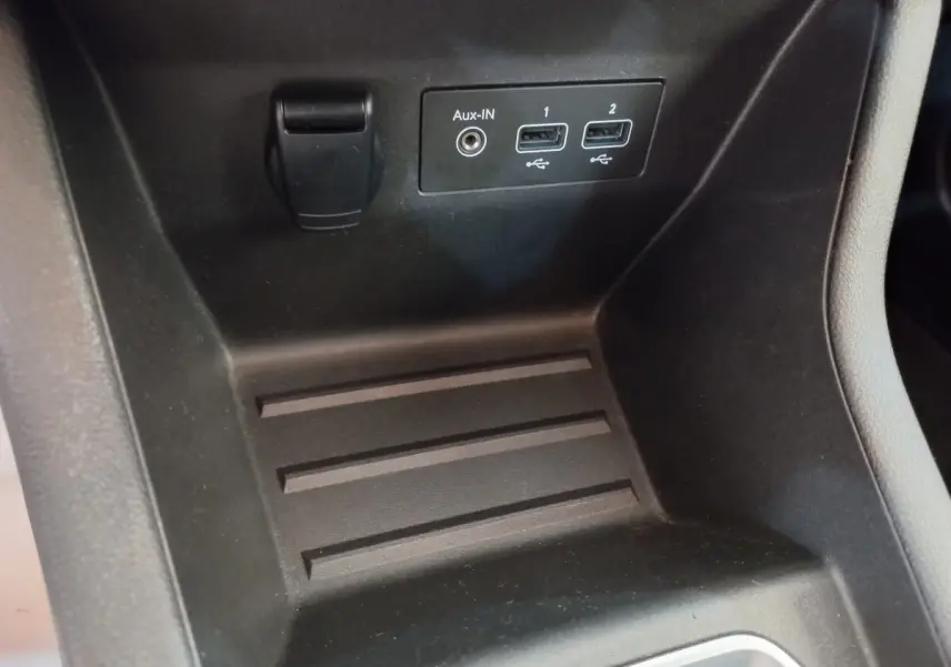 Gros plan sur la console centrale noire de la Renault Clio Business avec ports USB et prise Aux-In visibles.