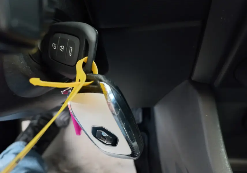 Gros plan sur la clé blanche Renault suspendue près du tableau de bord noir côté conducteur d'une Clio Business 2021.