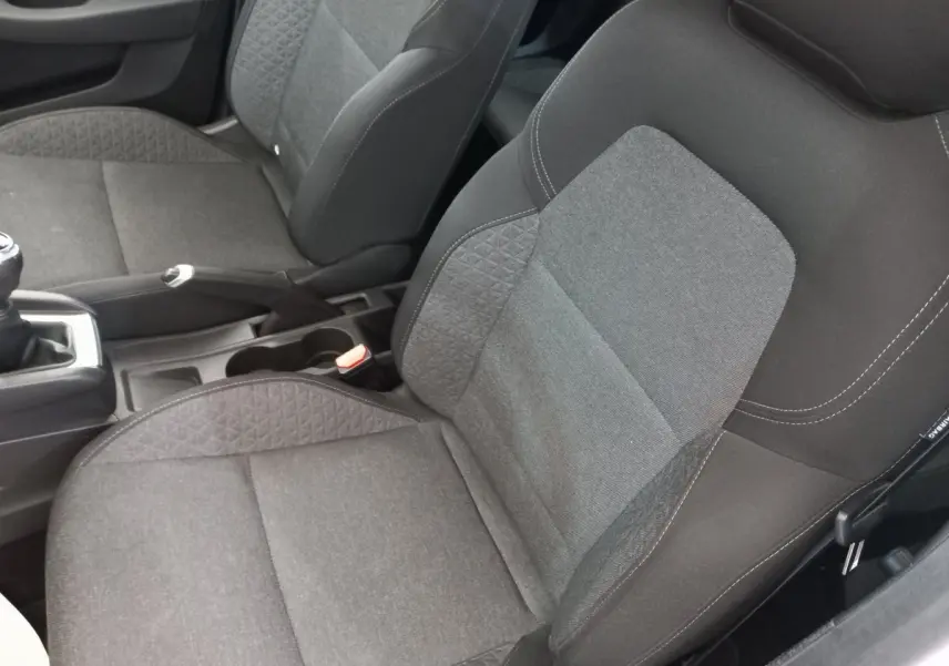 Gros plan sur les sièges avant gris foncé de la Renault Clio Business SCe 65, montrant la texture et les coutures.