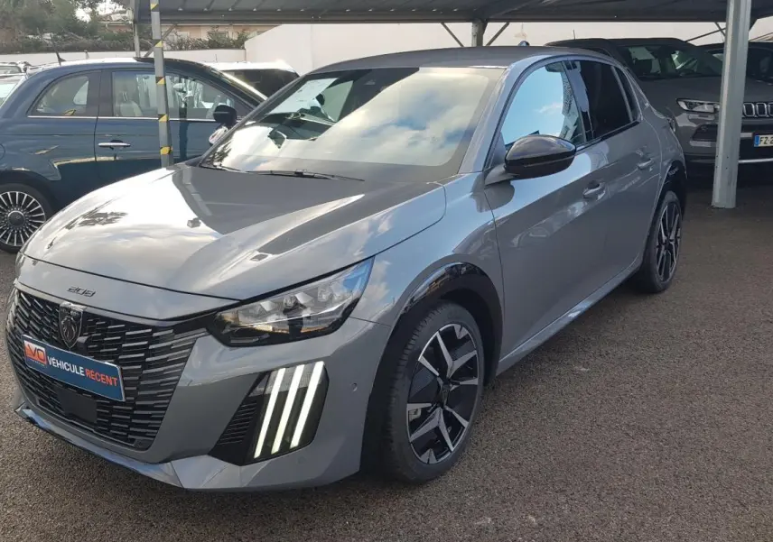 Peugeot 208 Hybrid gris vue 3/4 avant droit, feux diurnes verticaux allumés et jantes alliage 17 pouces.