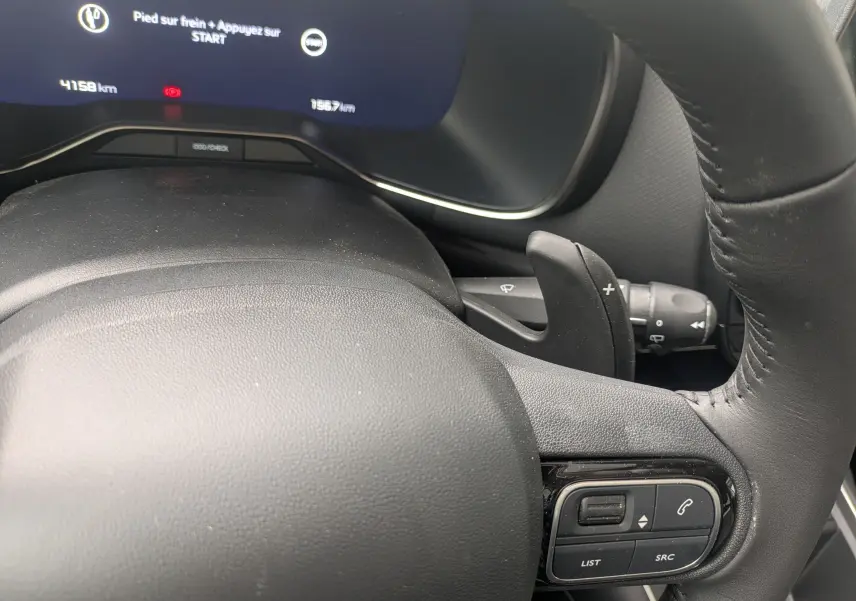 Gros plan sur le volant en croûte de cuir et le combiné numérique du Citroën C5 Aircross Hybride 2025, affichage digital visible.