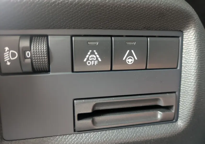 Gros plan sur les commandes d’aide à la conduite du tableau de bord du Citroën C5 Aircross hybride blanc.