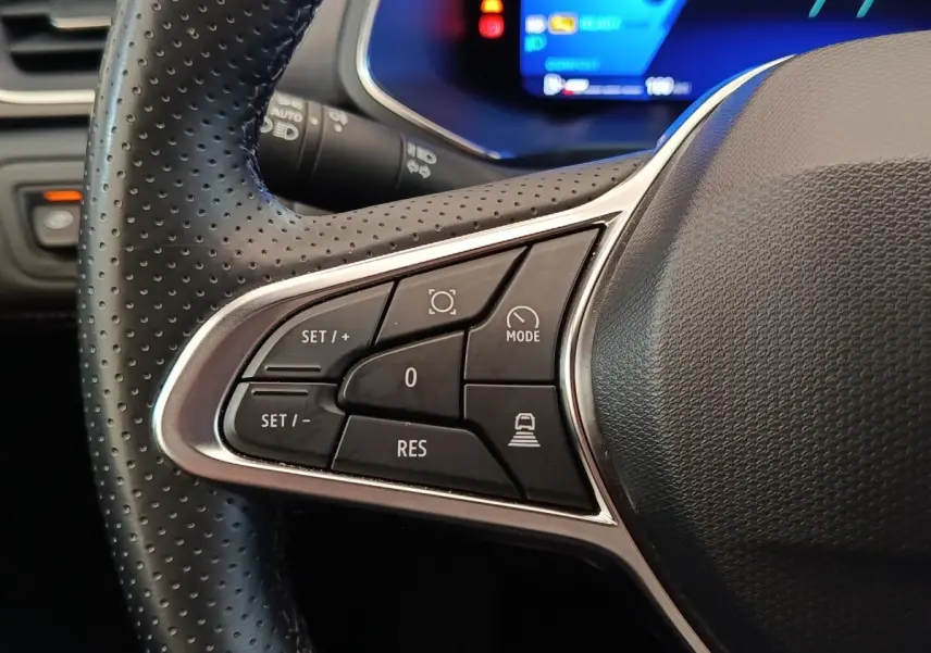 Gros plan sur les commandes multifonctions côté gauche du volant noir perforé de la Renault Symbioz 2025.
