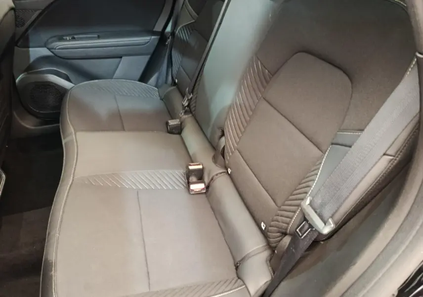 Vue intérieure côté droit sur la banquette arrière noire du Renault Symbioz 2025 avec ceinture et porte de porte visible.