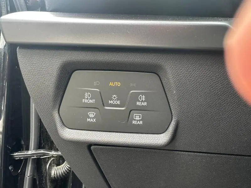 Vue rapprochée du panneau de commande d’éclairage automatique sur la gauche du tableau de bord d’une CUPRA Formentor noir Minuit métallisé.