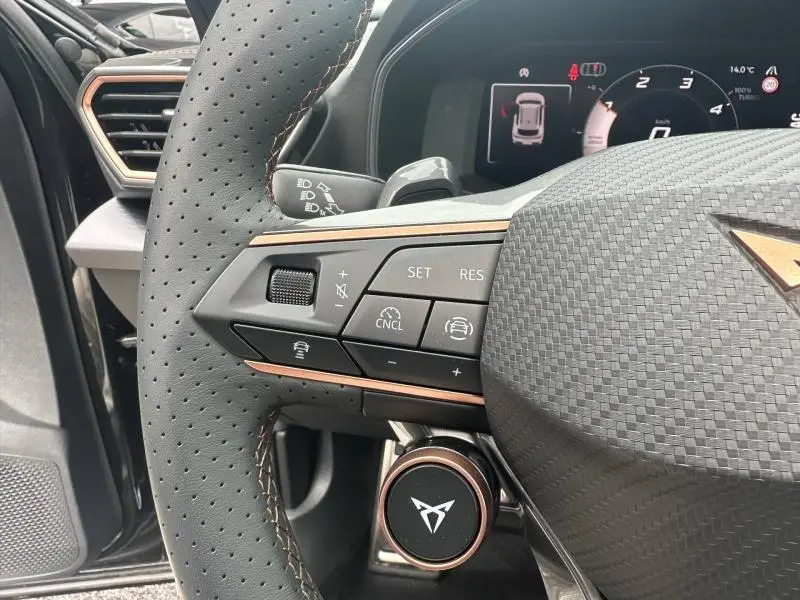 Gros plan sur le volant cuir noir perforé côté gauche du CUPRA Formentor 2.0 TDI avec commandes multifonctions et logo cuivre.