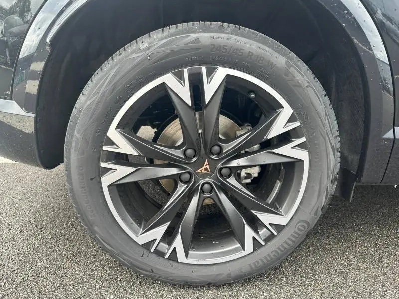Gros plan sur la jante alu noire et argentée au design anguleux du CUPRA Formentor noir Minuit métallisé, roue avant droite.