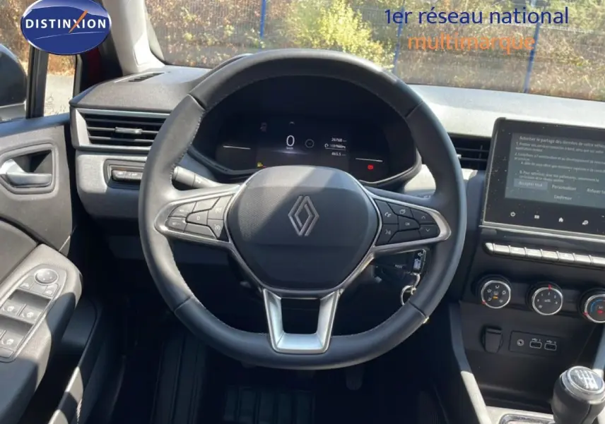 Vue intérieure centrée sur le volant cuir de la Renault Clio 2025, avec tableau de bord digital et console centrale moderne.