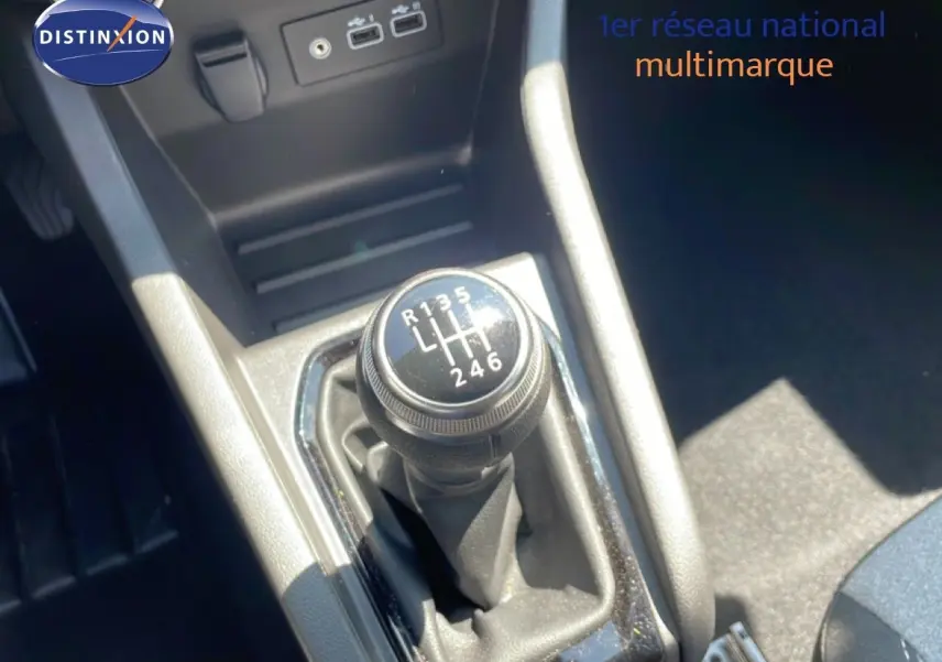 Gros plan sur le levier de vitesses manuel de la Renault Clio 2025, intérieur tissu noir avec connectiques USB visibles.