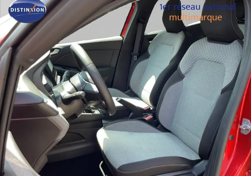 Vue intérieure côté gauche de la Renault Clio 2025 rouge flamme, montrant les sièges tissu gris et volant cuir multifonction.