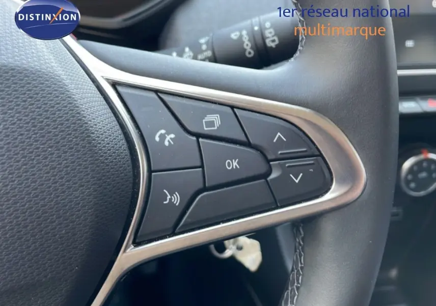 Gros plan sur les commandes multifonctions à droite du volant en cuir noir d'une Renault Clio 2025.