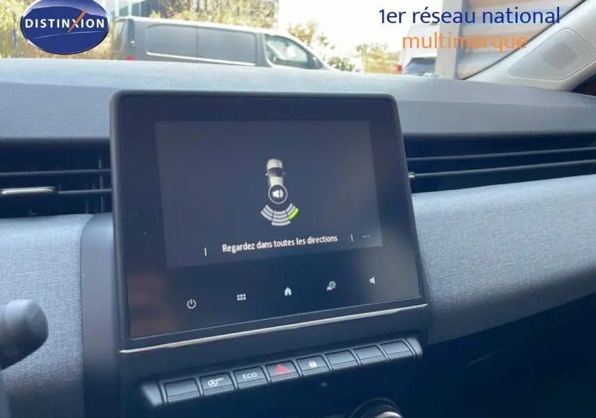 Vue rapprochée de l’écran tactile central et de la planche de bord grise intérieure d’une Renault Clio rouge flamme 2025.