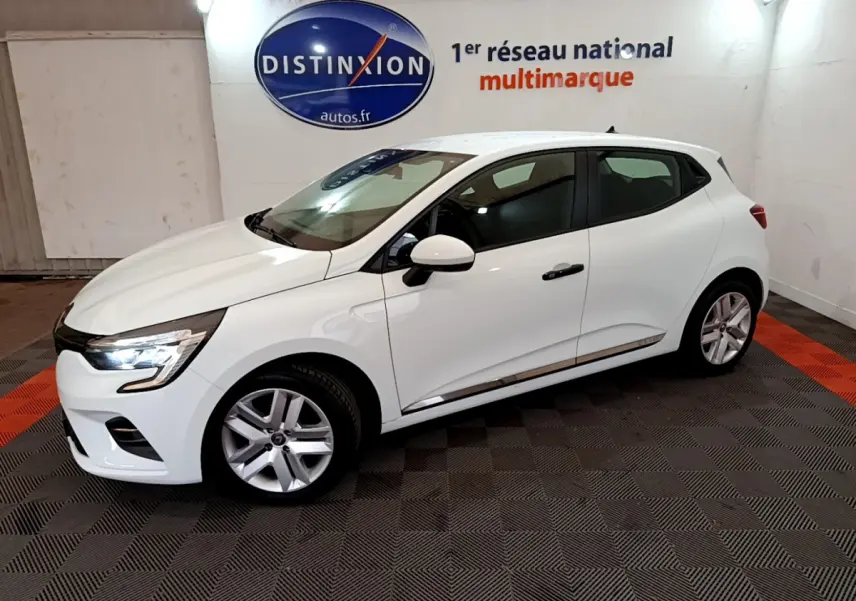 Renault Clio Business blanc vue de profil côté gauche avec feux LED allumés dans un showroom intérieur.