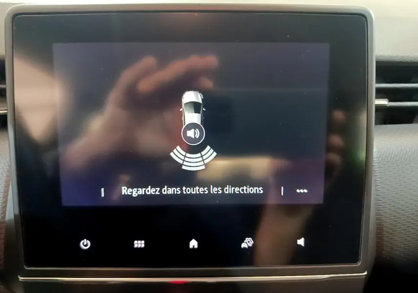 Écran tactile central de la Renault Clio Business blanc 2021 affichant l'alerte de détection d'obstacles.