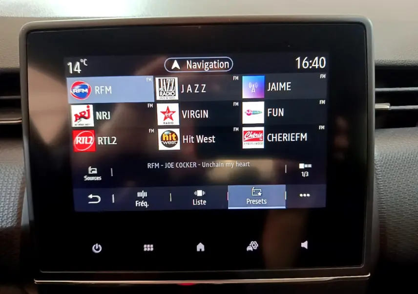 Écran tactile central de la Renault Clio Business blanc 2021 affichant les stations radio et la navigation.