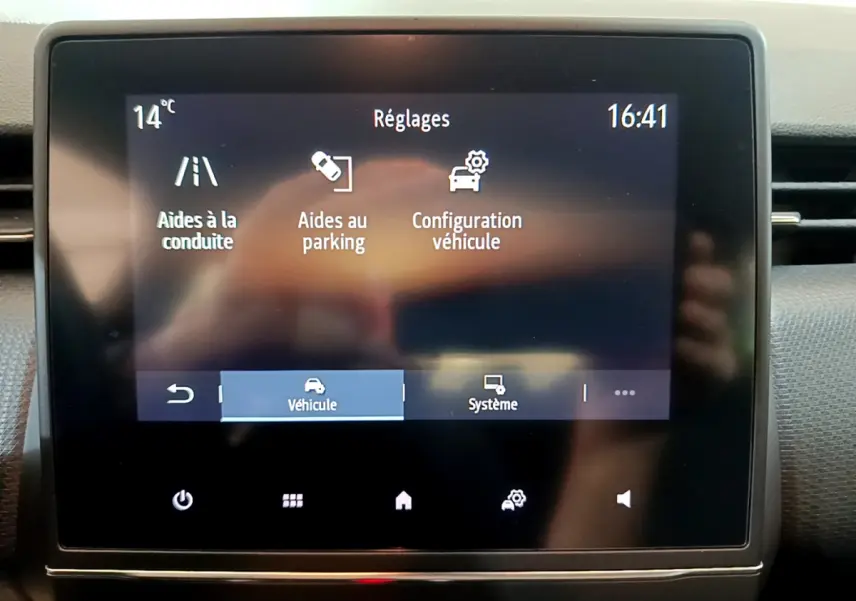 Écran tactile central de la Renault Clio Business blanc montrant les réglages d’aides à la conduite et parking