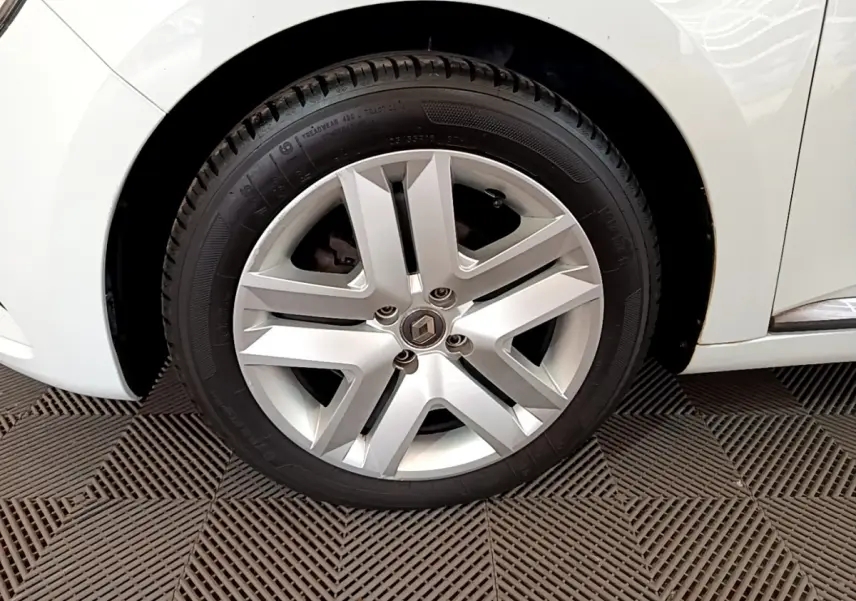 Gros plan sur la roue avant gauche blanche de la Renault Clio Business SCe 65 avec jante alliage argentée au design moderne.